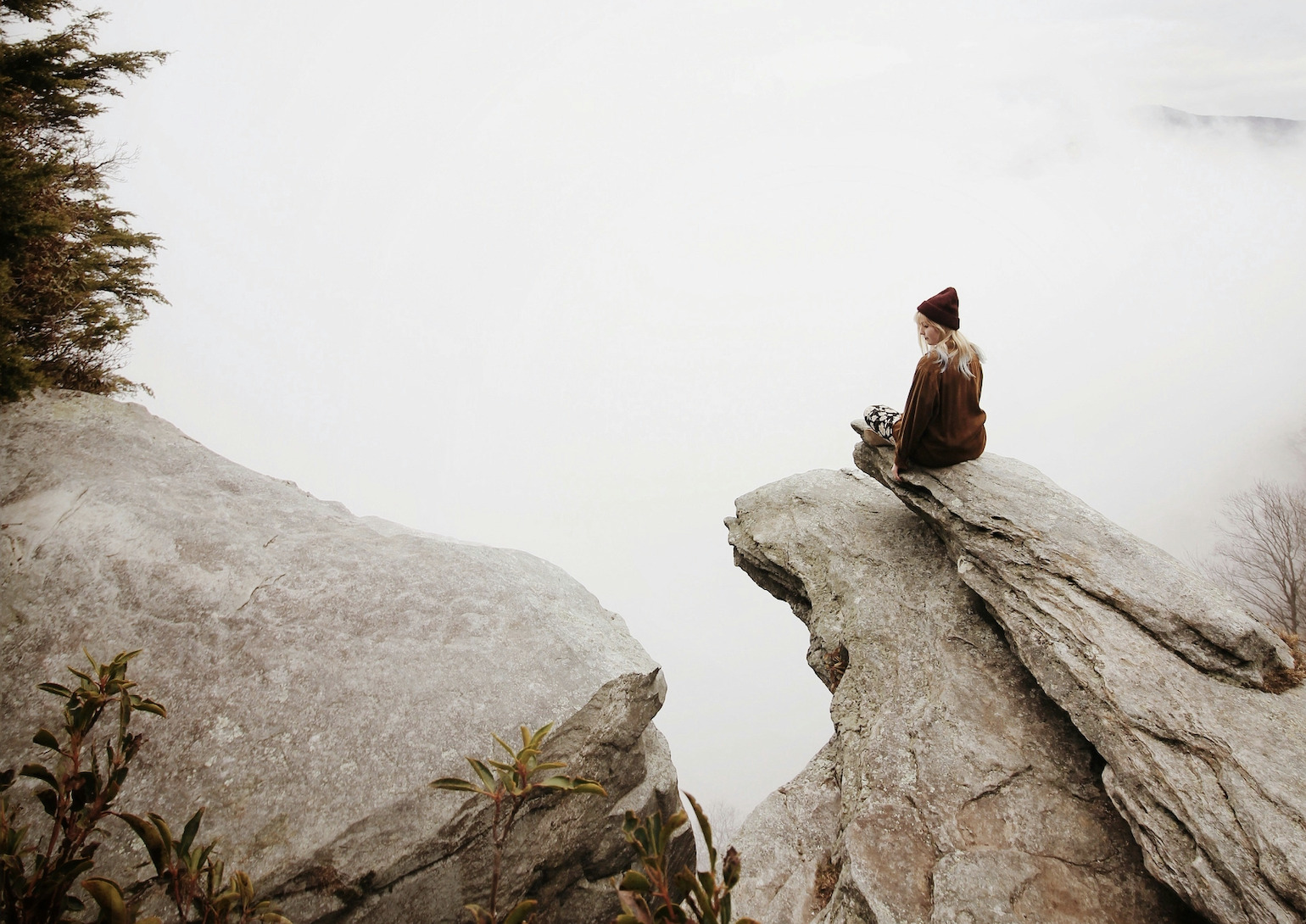 woman sitting on brown rock